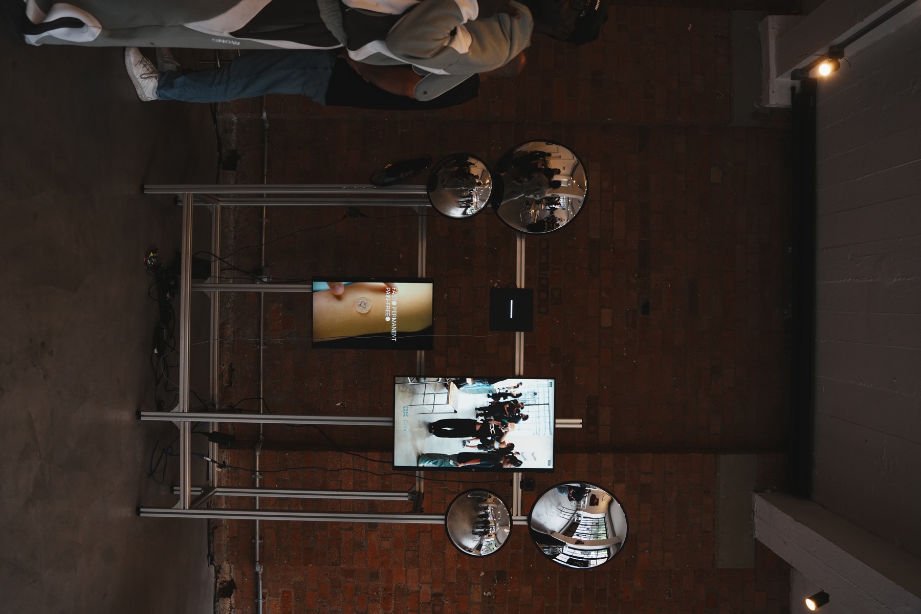 An industrial event space with freestanding digital displays and convex mirrors